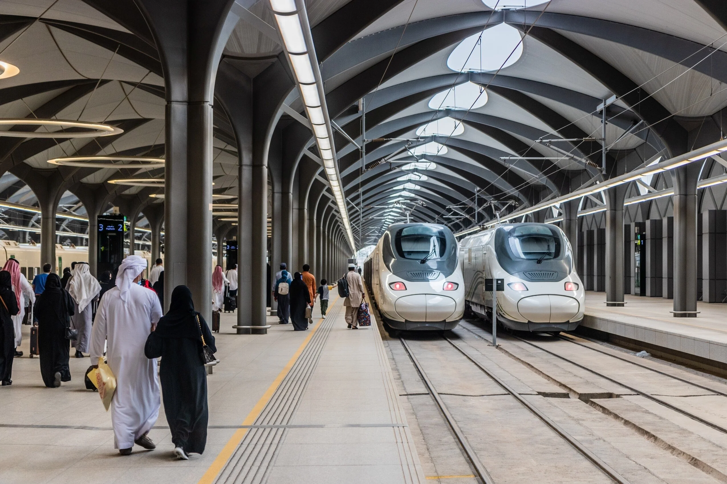 Haramain high speed train at Makkah station with Umrah pilgrims boarding

